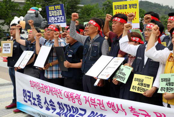 29일 서울 종로구 청와대 분수대 앞에서 한국노총 주최로 열린 기자회견에서 최저임금위원들이 ‘최저임금법 개정안’에 대한 대통령의 거부권 행사를 촉구하며 구호를 외치고 있다.  연합뉴스