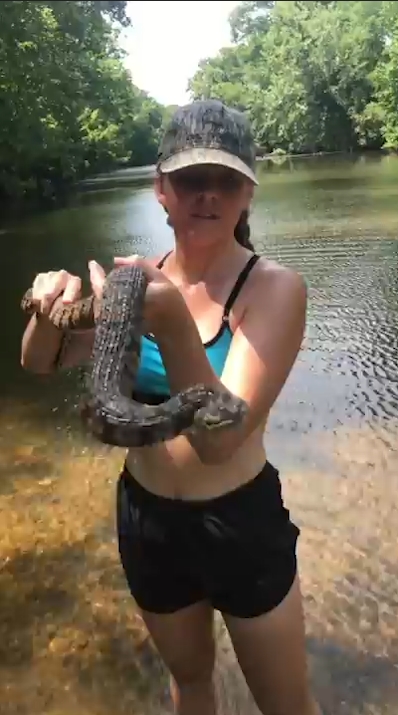 미국 아칸소(Arkansas)주 벤턴(Benton) 지역 설린(Saline)강에서 다이아몬드백(Diamondback) 물뱀 한마리를 잡고 있는 여성 모습(유튜브 영상 캡처)