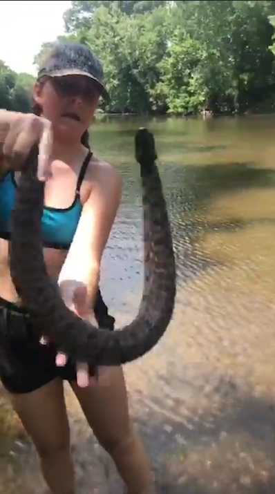 미국 아칸소(Arkansas)주 벤턴(Benton) 지역 설린(Saline)강에서 다이아몬드백(Diamondback) 물뱀 한마리를 잡고 있는 여성 모습(유튜브 영상 캡처)