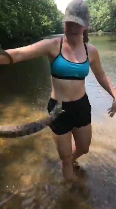 미국 아칸소(Arkansas)주 벤턴(Benton) 지역 설린(Saline)강에서 다이아몬드백(Diamondback) 물뱀 한마리를 잡고 있는 여성 모습(유튜브 영상 캡처)