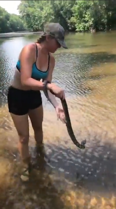 미국 아칸소(Arkansas)주 벤턴(Benton) 지역 설린(Saline)강에서 다이아몬드백(Diamondback) 물뱀 한마리를 잡고 있는 여성 모습(유튜브 영상 캡처)