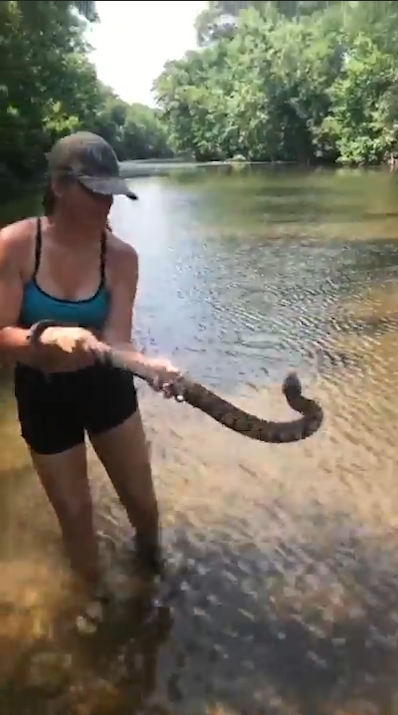 미국 아칸소(Arkansas)주 벤턴(Benton) 지역 설린(Saline)강에서 다이아몬드백(Diamondback) 물뱀 한마리를 잡고 있는 여성 모습(유튜브 영상 캡처)