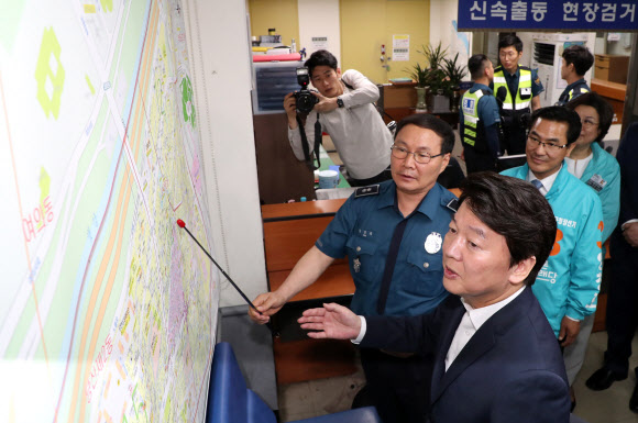 바른미래당 안철수 서울시장 후보가 6·13 지방선거 공식 선거운동 개시일인 31일 오전 손학규 선거대책위원장 등 당 지도부와 함께 첫 일정으로 서울 영등포 경찰서 중앙지구대를 방문해 관내 지도를 보며 설명을 듣고 있다. 2018.5.31  연합뉴스