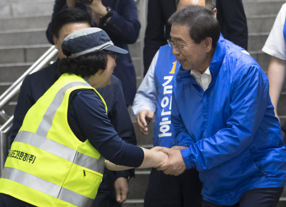 6·13 지방선거 공식 선거운동 개시일인 31일 새벽 더불어민주당 박원순 서울시장 후보가 답십리역 역사 내에서 지하철 청소노동자와 악수를 하고 있다. 2018.5.31  연합뉴스