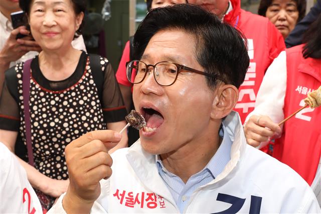 김문수 자유한국당 서울시장 후보가 6.13지방선거 선거운동이 시작된 31일 오후 서울 중구 중앙시장에서 시민들에게 지지를 호소한 뒤 순대를 먹고 있다. 2018.5.31 뉴스1