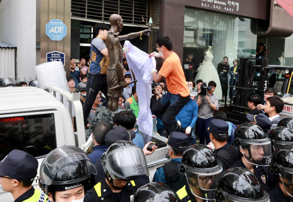 31일 오후 부산 동구청 관계자들이 지게차와 트럭을 이용해 부산 일본총영사관 인근 인도 앞에 놓여 있는 강제징용노동자상을 행정대집행을 통해 강제철거하고 있다. 2018.5.31  연합뉴스
