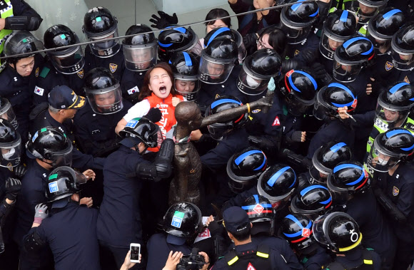 31일 오후 부산 초량동 일본총영사관 앞에 있는 강제징용노동자상이 행정대집행을 통해 강제철거되자 이를 막는 시민단체와 경찰이 충돌하고 있다. 20여분 간의 철거작업 끝에 일본영사관 앞 인도를 떠난 노동자상은 부산 남구 일제강제동원역사관에 ‘임시보관’될 예정이다.  2018.5.31  연합뉴스