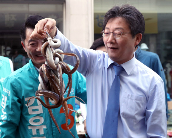 바른미래당 유승민 공동대표(오른쪽)가 1일 오전 경남 진주 중앙시장을 찾아 시장에서 판매하는 장어를 들어 올리고 있다. 왼쪽은 김유근 경남도지사 후보. 2018.6.1  연합뉴스
