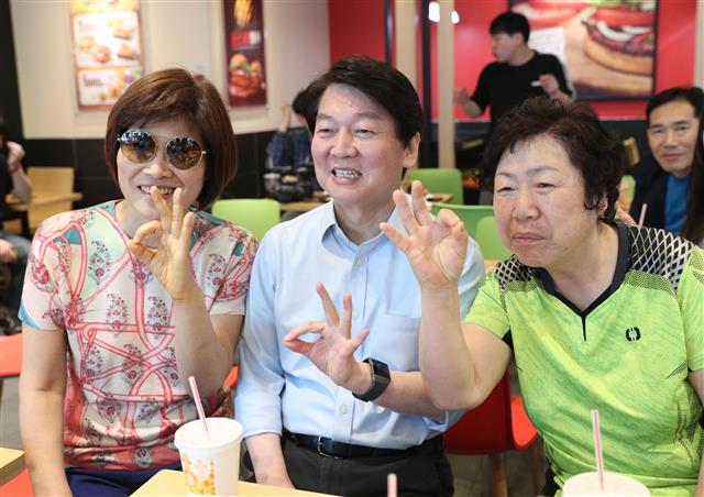 안철수 바른미래당 서울시장 후보가 1일 오전 서울 관악구의 한 햄버거 가게에서 시민들과 손가락 포즈를 취하고 있다. 2018.6.1 뉴스1