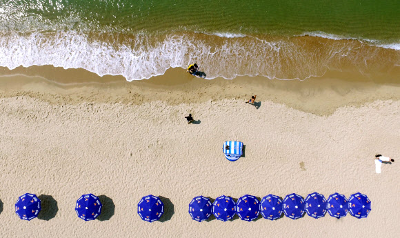 초여름 날씨를 보인 1일 문을 연 부산 해운대해수욕장에서 나들이객들이 더위를 식히고 있다. 송정·송도 해수욕장도 한 달 일찍 이날 문을 열었고 광안리·다대포·일광·임랑해수욕장은 7월 1일 공식 개장한다. 2018.6.1  연합뉴스