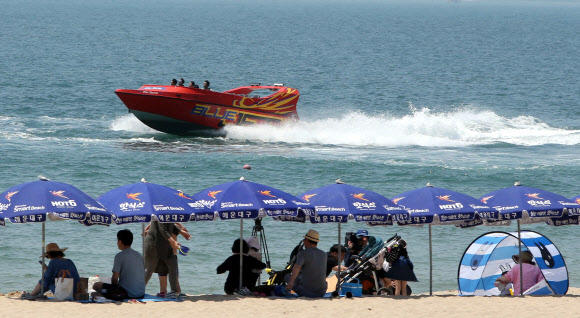 1일 개장한 부산 해운대해수욕장에서 해양레저 보트가 바다를 질주하고 있다. 송정·송도 해수욕장도 한 달 일찍 이날 문을 열었고 광안리·다대포·일광·임랑해수욕장은 7월 1일 공식 개장한다. 2018.6.1  연합뉴스