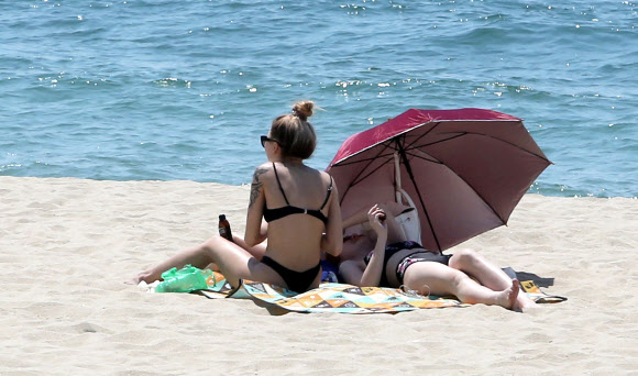 1일 문을 연 부산 해운대해수욕장에서 외국인들이 일광욕을 즐기고 있다. 송정·송도 해수욕장도 한 달 일찍 이날 문을 열었고 광안리·다대포·일광·임랑해수욕장은 7월 1일 공식 개장한다. 2018.6.1  연합뉴스