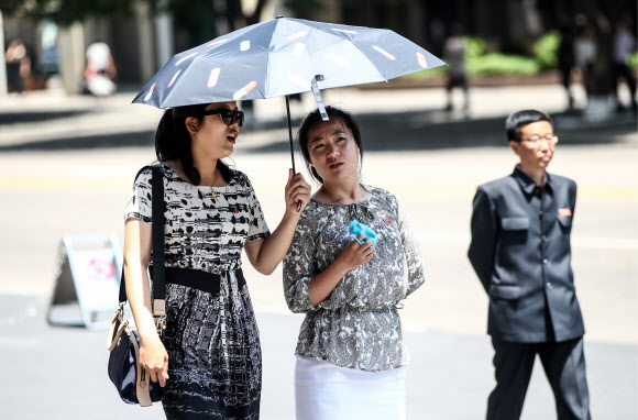 지난달 31일 촬영된 북한 평양 시내 모습이 공개됐다. 공개된 사진에는 더워진 날씨에 가벼운 옷차림을 한 북한 주민들이 거리를 지나고 있다.  TASS 연합뉴스