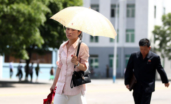 지난달 31일 촬영된 북한 평양 시내 모습이 공개됐다. 공개된 사진에는 더워진 날씨에 가벼운 옷차림을 한 북한 주민들이 거리를 지나고 있다.  TASS 연합뉴스