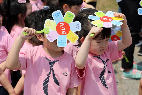 4일 대구시 달서구 두류공원에서 모의투표 체험을 하는 어린이들이 선거안내 부채로 뜨거운 햇볕을 피하고 있다. 2018.6.4  연합뉴스