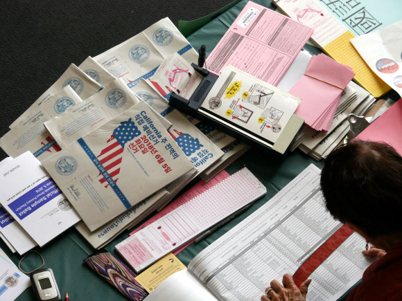 미국 캘리포니아주를 포함한 8개 주에서 오는 11월 중간선거(본선)에 나갈 후보들을 뽑는 예비 선거(프라이머리)가 5일(현지시간) 시작된 가운데 선거 관리자들이 샌타모니카시청에서 투표 등록자들의 이름을 관련 서류들과 대조하며 꼼꼼하게 점검하고 있다. 한인 여성으로는 처음으로 미 연방하원 의원에 도전한 영 김 전 캘리포니아주 하원 의원이 개표 결과 득표율 1위로 본선에 진출했다. 도널드 트럼프 미 정부의 중간평가 성격인 중간선거에서 민주당은 하원 23석 이상을 더 따내 원내 다수당 지위를 회복하겠다는 전략을 세우고 있으며, 이번 예비선거는 그 전초전이다.  샌타모니카 EPA 연합뉴스