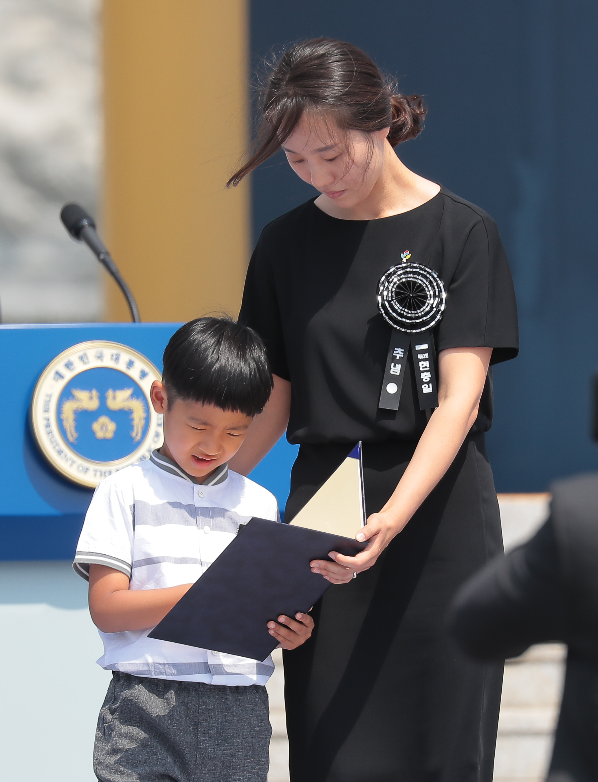 6일 오전 국립대전현충원에서 열린 제 63회 현충일 추념식에서 유공자증을 받은 고 정연호 경위 가족이 유공자증을 바라보고 있다. 2018.06.60 청와대 사진기자단
