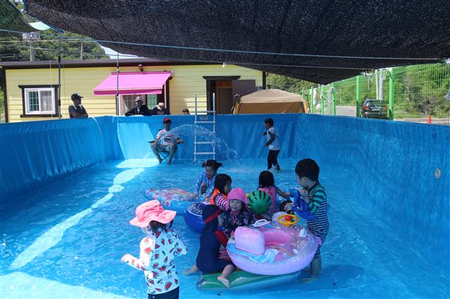지난달 26일 대구 안심마을 공동체의 공동육아 협동조합인 ‘동동 어린이집’ 아빠들이 만든 수영장에서 아이들이 신나게 물놀이를 하고 있다.
