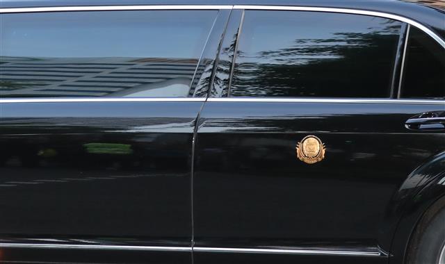 김정은 북한 국무위원장이 북미정상회담을 이틀 앞둔 10일 리셴륭 싱가포르 총리를 만나기 위해 차량을 타고 세인트레지스 호텔을 나서고 있다. 차량뒷문에 새겨진 휘장에 국무위원장이라고 적혀있다. 2018.6.10 뉴스1