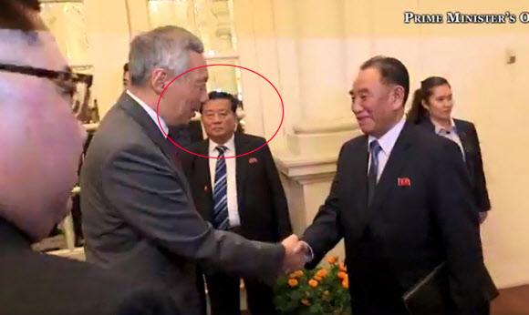 김정은 북한 국무위원장의 ‘밀착’ 경호부대 책임자로 알려진 인물(붉은 원)이 10일 김 위원장과 리셴룽 싱가포르 총리의 면담 모두발언 영상에 등장한 모습. 연합뉴스