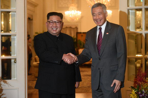 북·미 정상회담을 이틀 앞둔 10일 오후 싱가포르 총리 집무실인 이스타나에서 북한 김정은(왼쪽) 국무위원장과 리셴룽 싱가포르 총리가 정상회담을 갖기에 앞서 활짝 웃으며 악수를 하고 있다. 싱가포르 AFP 연합뉴스