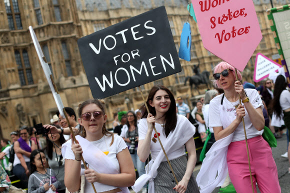 10일(현지시간) 영국 런던에서 여성 참정권 쟁취 100주년을 기념한 여성들이 플래카드를 든 채 행진하고 있다. 이날 수만여명의 여성들이 ‘서프러제트’(영국 여성 참정권 운동을 일컫는 말)를 상징하는 녹색과 흰색, 보라색 스카프를 몸에 걸친 채 영국 전역에서 축하 행사를 벌였다.  런던 AFP 연합뉴스