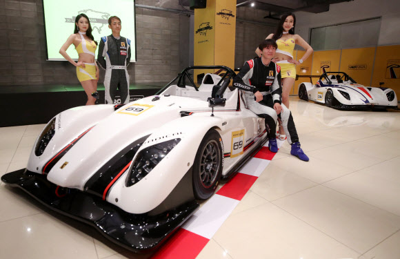 12일 오전 서울 강남구 JBK 컨벤션홀에서 드라이버 연정훈과 한민관이 모델들과 함께 레이싱카 레디컬 2세대 SR1을 선보이고 있다. ‘SR1’은 공차중량 490kg의 초경량 바디와 공기역학적 설계로 이뤄진 레이싱카로 최고출력 182마력, 최고속도 시속 222km을 발휘한다. 2018.6.12  연합뉴스