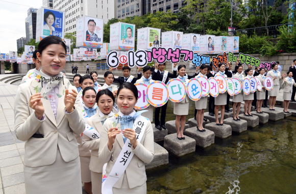 지방선거를 하루 앞둔 12일 서울 청계천 모전교 인근에서 아세아항공직업전문학교 재학생, 아름다운 지방선거 홍보대사 등이 ‘6.13 아름다운 지방선거 투표참여 캠페인’을 하고 있다. 2018.6.12  정연호 기자 tpgod@seoul.co.kr
