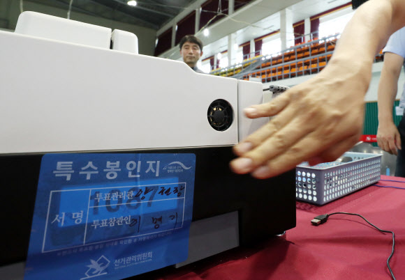 6·13 지방선거를 하루 앞둔 12일 오후 세종시 세종시민체육관에서 선관위 관계자들이 투표지 분류기를 점검한 뒤 봉인하고 있다. 2018.6.12  연합뉴스