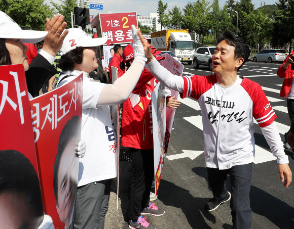 6·13 지방선거 선거운동 마지막 날인 12일 오후 자유한국당 남경필 경기도지사 후보가 경기도 안산시 상록구 다농마트 사거리에서 선거운동원들과 하이파이브를 하고 있다. 2018.6.12  연합뉴스