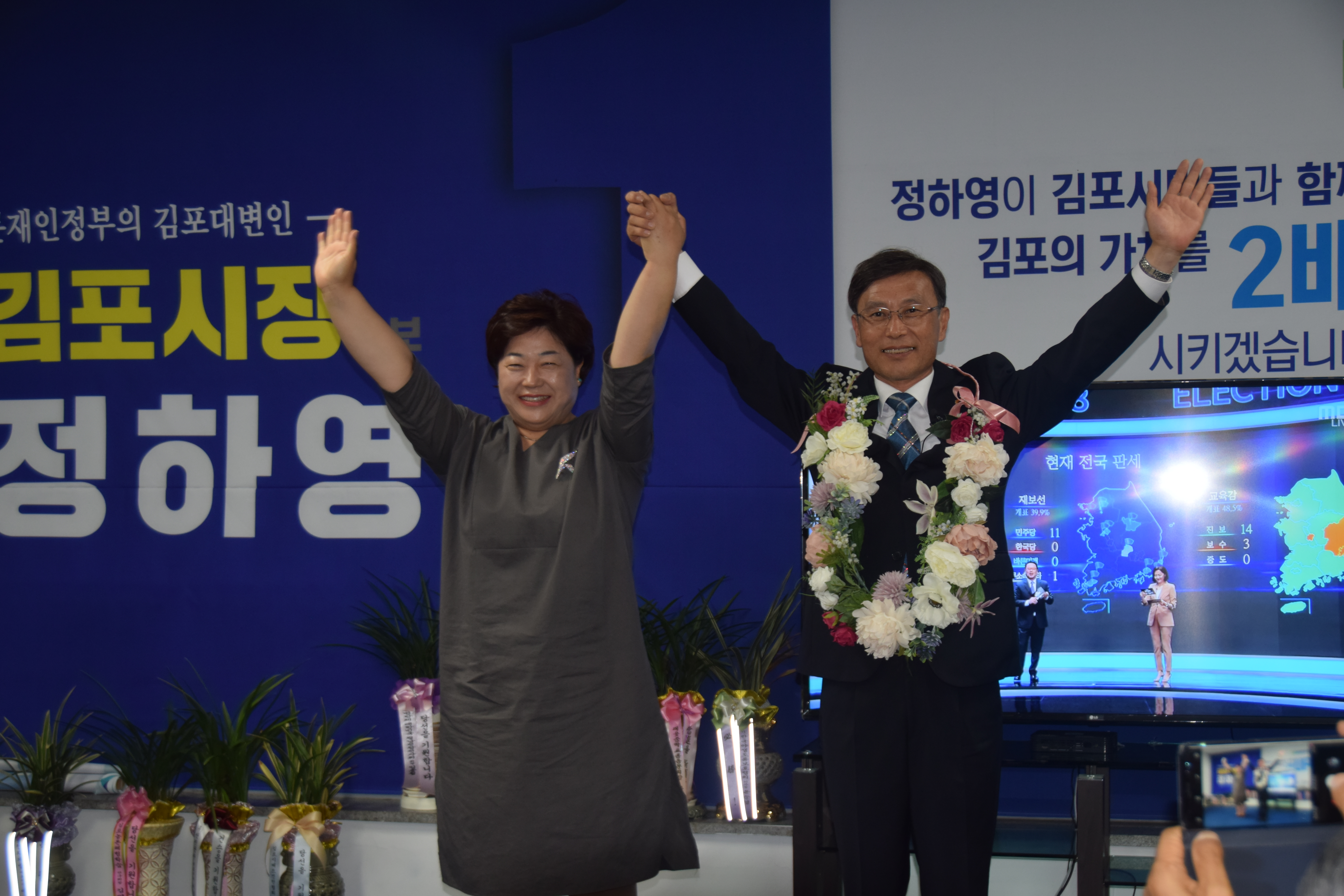정하영(오른쪽) 김포시장 당선인이 당선이 확정된 뒤 부인 방혜란씨의 손을 치켜들며 기뻐하고 있다. 정하영 후보측 제공