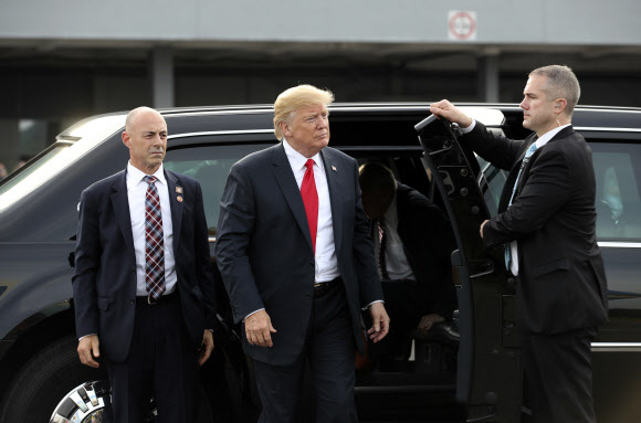 도널드 트럼프(가운데) 미국 대통령이 지난 12일 북한 김정은 국무위원장과의 정상회담을 마치고 에어포스원을 타고 출국하기 위해 공항에 도착하고 있다.  싱가포르 공보부 제공