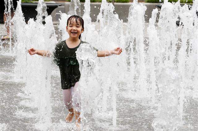 서울 낮기온이 28도까지 오르는 등 더운 날씨를 보인 17일 오후 서울 세종대로 광화문광장 분수대에서 한 어린이가 물놀이를 하고 있다. 2018.6.17/뉴스1