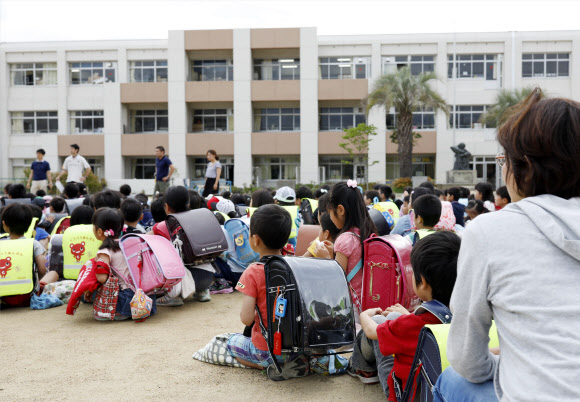 18일 오전 일본 오사카에서 규모 5.9로 추정되는 지진이 발생한 가운데 이케다의 한 초등학교 운동장에 학생들이 운동장으로 대피해있다. AP 연합뉴스