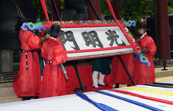 19일 서울 덕수궁에서 열린 광명문 제자리 찾기 기공식에서 수문장들이 잘못 설치된 광명문 현판을 제거하고 있다. 2018.6.19 박지환기자 popocar@seoul.co.kr