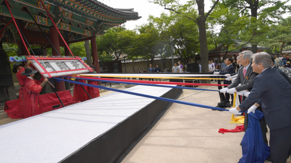 19일 서울 덕수궁에서 열린 광명문 제자리 찾기 기공식에서 참석자들이 일제에 의해 잘못 설치된 광명문 현판을 제거하고 있다. 2018.6.19 박지환기자 popocar@seoul.co.kr