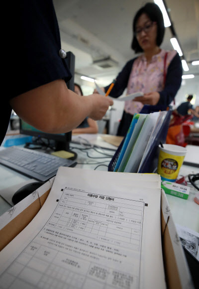 20일 서울 서대문구 남가좌1동 주민센터에서 아이 엄마들이 오는 9월부터 아동 1명당 월 10만원씩 지급되는 아동수당을 신청하고 있다.  9월분 수당의 경우 만 6세를 앞둔 2012년 10월 출생아까지 지급된다. 가구 소득과 재산을 더한 소득인정액이 3인 가구 기준 월 1천170만원 이하, 4인 가구 월 1천436만원 이하, 5인 가구 1천702만원, 6인 가구 1천968만원 이하일 경우만 수당을 받는다. 아동수당 지급 대상 아동의 보호자나 대리인은 이날부터 아동의 주소지 주민센터를 방문하거나 복지로 홈페이지(www.bokjiro.go.kr), 모바일 앱 등을 통해 수당을 신청할 수 있다. 2018.6.20  연합뉴스