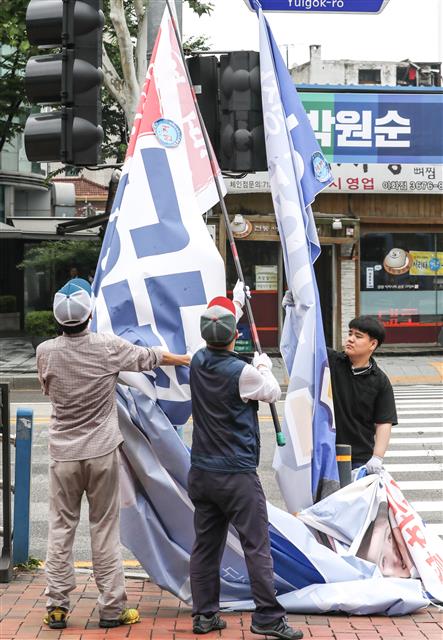 6·13지방선거 다음날인 14일 오전 서울 종로구 이화사거리에서 구청 직원들이 선거 운동 기간 동안 후보자들이 걸어 놨던 현수막을 철거하고 있다.  뉴스1