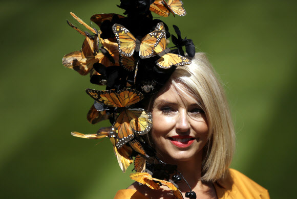 21일(현지시간) 영국 잉글랜드 버크셔카운티 애스컷에서 열린 ‘여성의 날(Ladies Day)’로 알려진 ‘로얄 애스컷 경마 대회(the Royal Ascot horse race meeting)’ 셋째 날에 관람을 하려는 여성이 화려한 모자를 쓰고 포즈를 취하고 있다. AP 연합뉴스