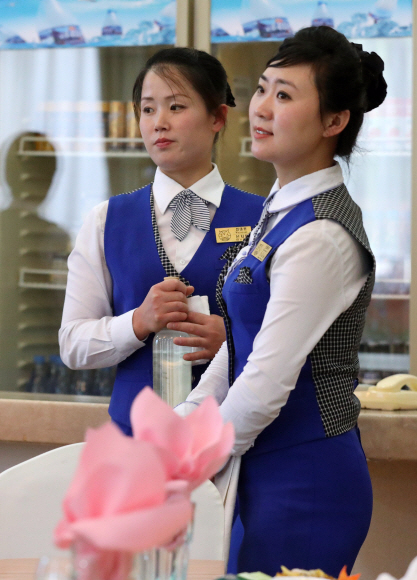 22일 북한 금강산호텔에서 8·15를 계기로 이산가족 상봉행사를 논의하기 위한 남북 적십자회담이 열렸다. 이번 회담에는 우리측 수석대표로 박경서 대한적십자사 회장이 북측 수석대표로 박용일 조국평화통일위원회 부위원장이 참석했다.  사진은 이날 우리측 대표단과 수행원 기자단에게 오찬장에서 서빙을 하는 금강산호텔 접대원. 2018.6.22 사진공동취재단