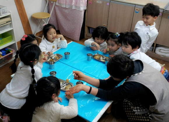 어린이의 식사를 돕는 보육교사. 서울신문 DB