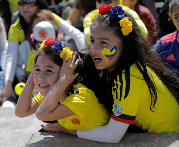 24일(현지시간) 콜롬비아 보고타에서 아이들이 2018 러시아 월드컵  H조 콜롬비아와 폴란드의 경기를 대형스크린을 통해 보면서 즐거워하고 있다. 이 경기에서 콜롬비아는 폴란드를 3대0으로 이겼다. 2018.6.24. AFP 연합뉴스