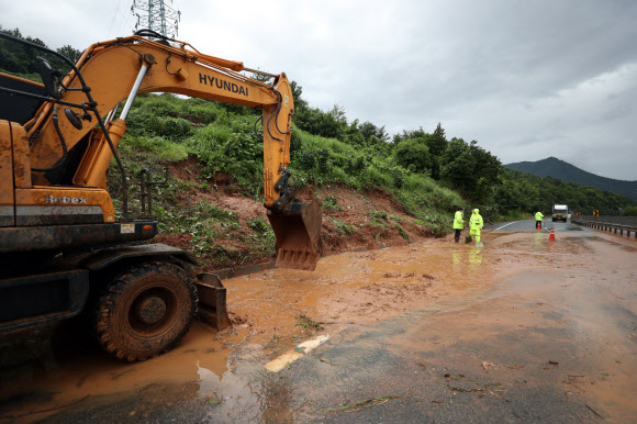 광주와 전남에 장맛비가 내린 28일 오전 강진군 성전면 한 도로에 토사가 흘러내려 중장비가 동원돼 현장을 정리하고 있다. 2018.6.28  연합뉴스