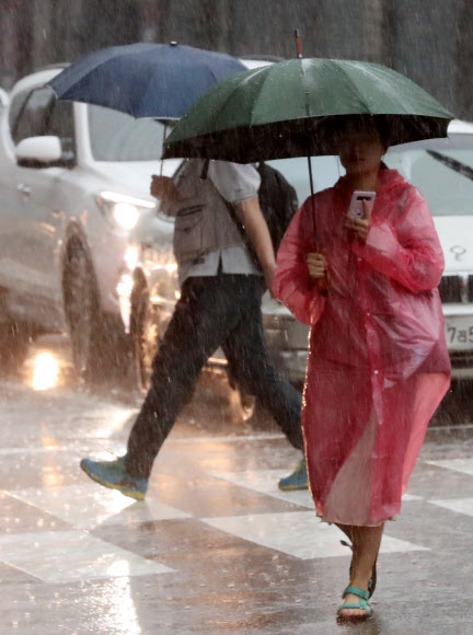부산에 호우경보가 내려진 28일 오전 부산 동래구 온천천 인근에서 시민들이 우산을 쓰고 출근길을 재촉하고 있다.  2018.6.28  연합뉴스