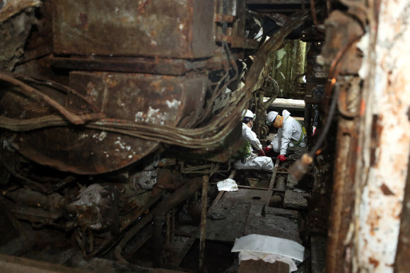 28일 전남 목포신항에 거치된 세월호 주기관실 내부에서 작업자들이 진흙덩이를 거둬들이며 미수습자 흔적을 찾고 있다. 2018.6.28  연합뉴스