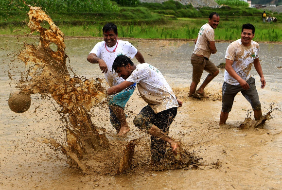 네팔의 젊은이들이 29일(현지시간) 카트만두 외곽의 레 마을(Lele village)의 논에서 즐거운 시간을 보내고 있다. 네팔의 농부들은 매년 모내기 시즌이 시작되면 ‘National Paddy Day’를 기념하고 있다. AFP 연합뉴스