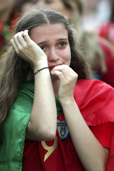 30일(현지시간) 러시아 소치의 피시트 스타디움에서 열린 ‘2018 러시아 월드컵’ 16강전 우루과이와 포르투갈의 경기에서 포르투갈의 8강 진출이 좌절되자 소녀팬이 눈물을 터뜨리고 있다.  EPA 연합뉴스