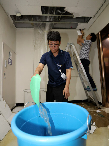 2일 오전 정부세종청사 교육부 지하 1층에서 정부청사관리본부 직원들이 물을 퍼내고 있다.관리본부측은 침수원인이 집중호우가 아니라 1층에서 지하층으로 배수시험을 했기 때문이라고 밝혔다. 2018.7.2  연합뉴스