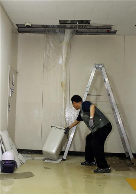 정부청사관리본부 직원이 2일 정부세종청사 교육부 지하 1층에서 떨어지는 물을 받기 위한 통을 세우고 있다.  청사관리본부 관계자는 이 곳에 빗물로 인한 소량의 누수가 있었던 것은 사실이나 이번 침수 원인은 누수 원인을 찾기 위해 1층에서 지하층으로 배수시험을 했기 때문이라고 설명했다. 2018.7.2 뉴스1