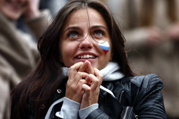 러시아 여성 축구팬이 1일(현지시간) 러시아 상트페테르부르크의 팬 존에서 러시아와 스페인의 16강 경기를 지켜보고 있다. 로이터 연합뉴스